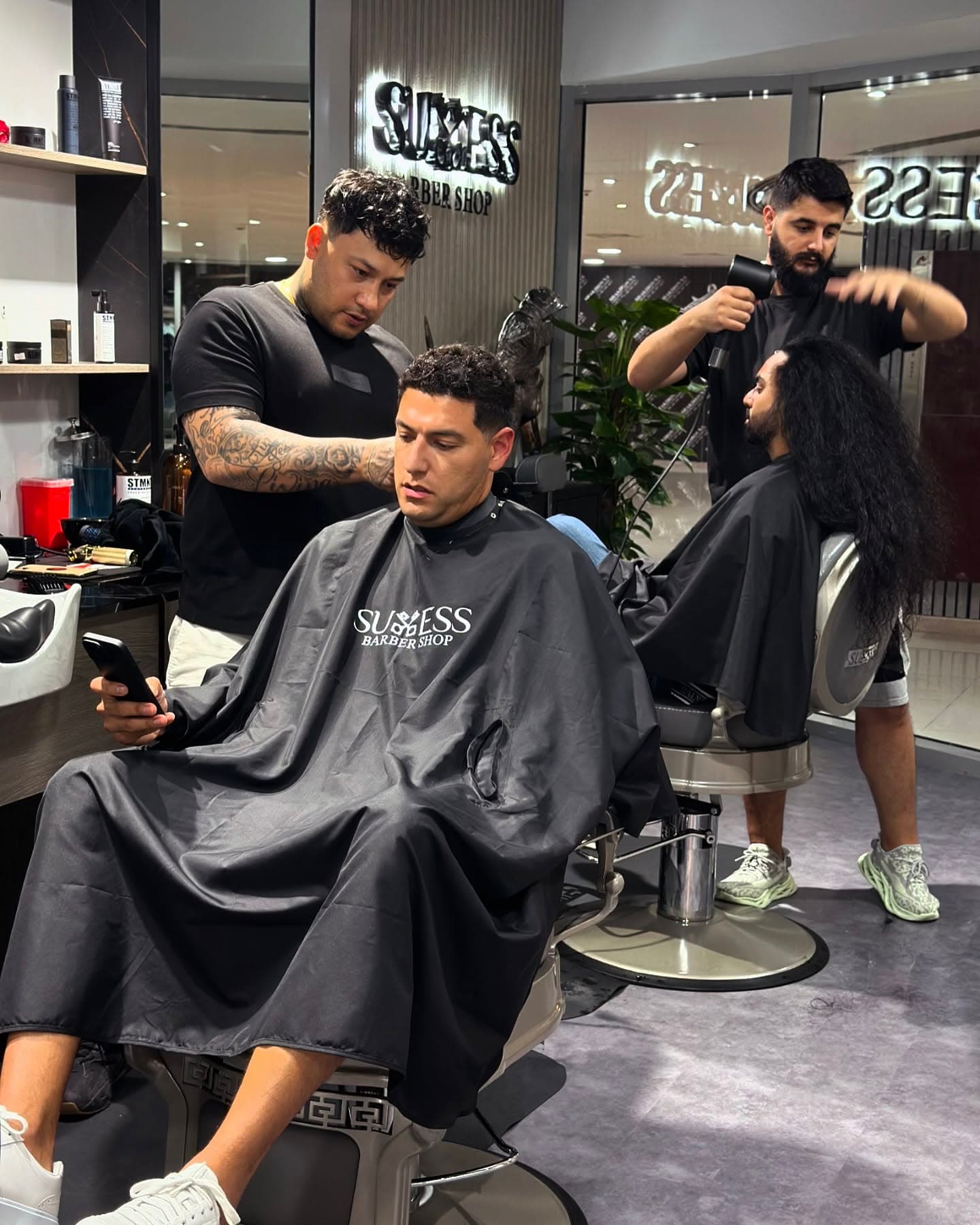 Success Barbershop interior — barbers at work in Dubai